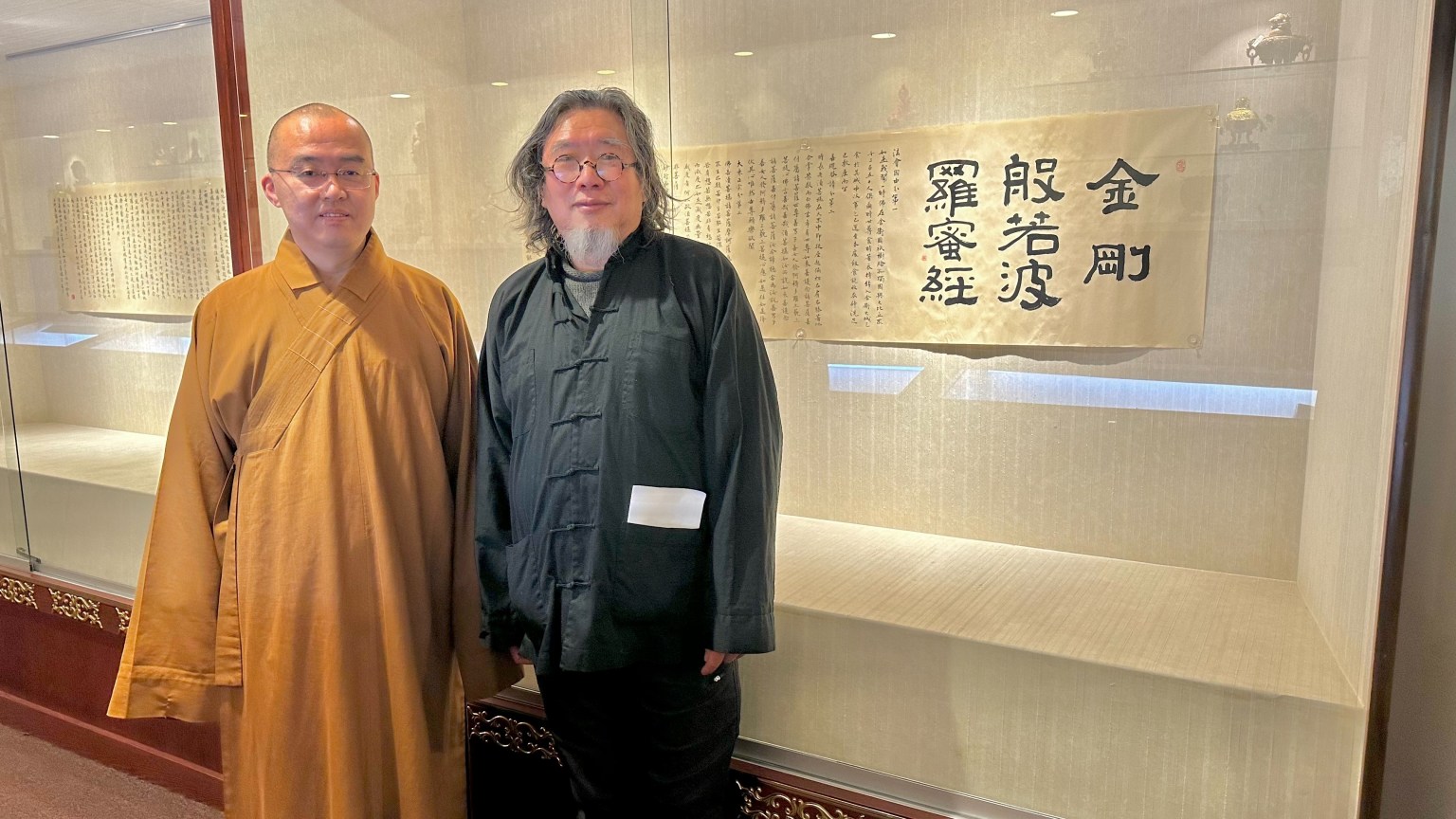 藝術家唐慶年(右)捐贈其楷體書寫的《金剛經》予西來寺典藏