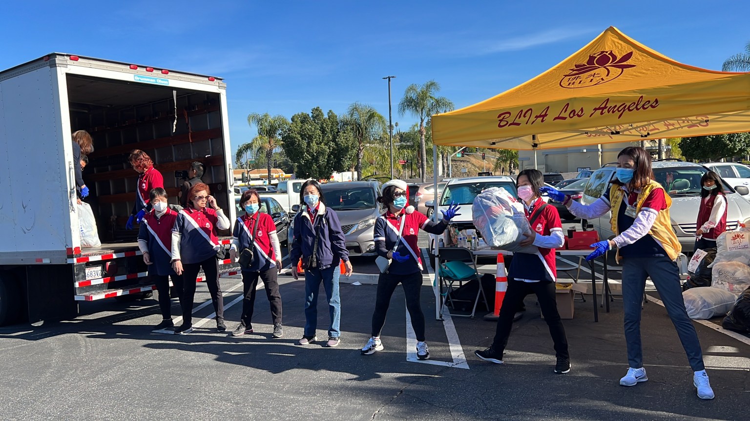 長堤分會義工們用接力方式把捐贈物品傳遞到貨車上