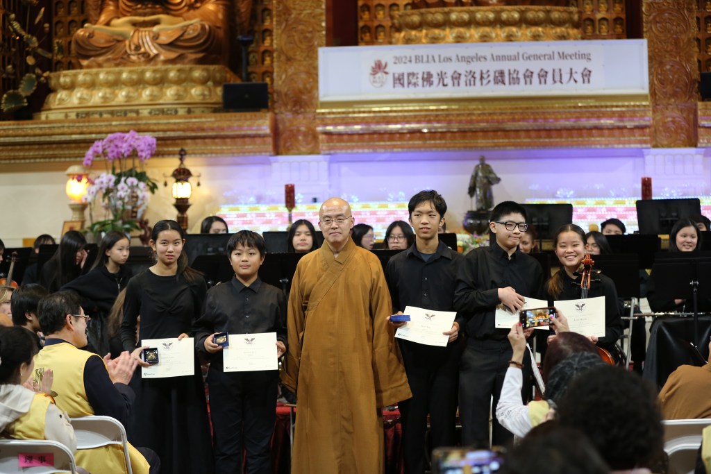 住持慧東法師頒發「總統義工服務獎」金獎給發心青年，表揚他們在社會服務中的卓越貢獻