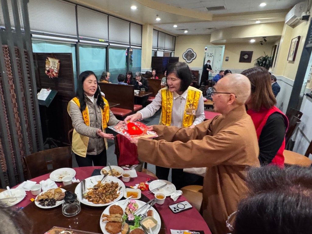 和輔導法師知杉法師一同，向在座的每一位會員分送由分會所準備的「福」袋及「福」字新春裝飾，現場氣氛熱烈。