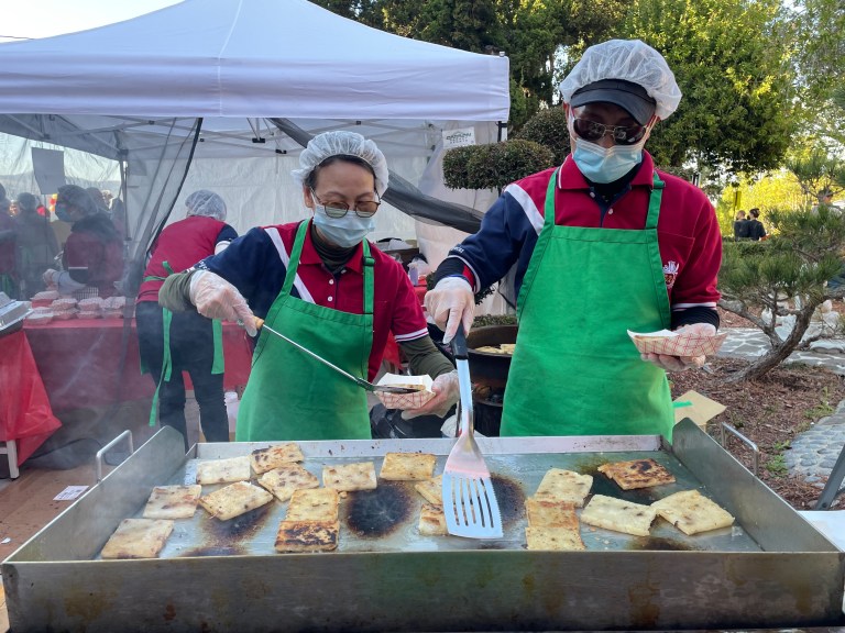 義工們以慈悲心為遊客們煎製香氣撲鼻的蘿蔔糕。（照片提供羅蘭一分會）