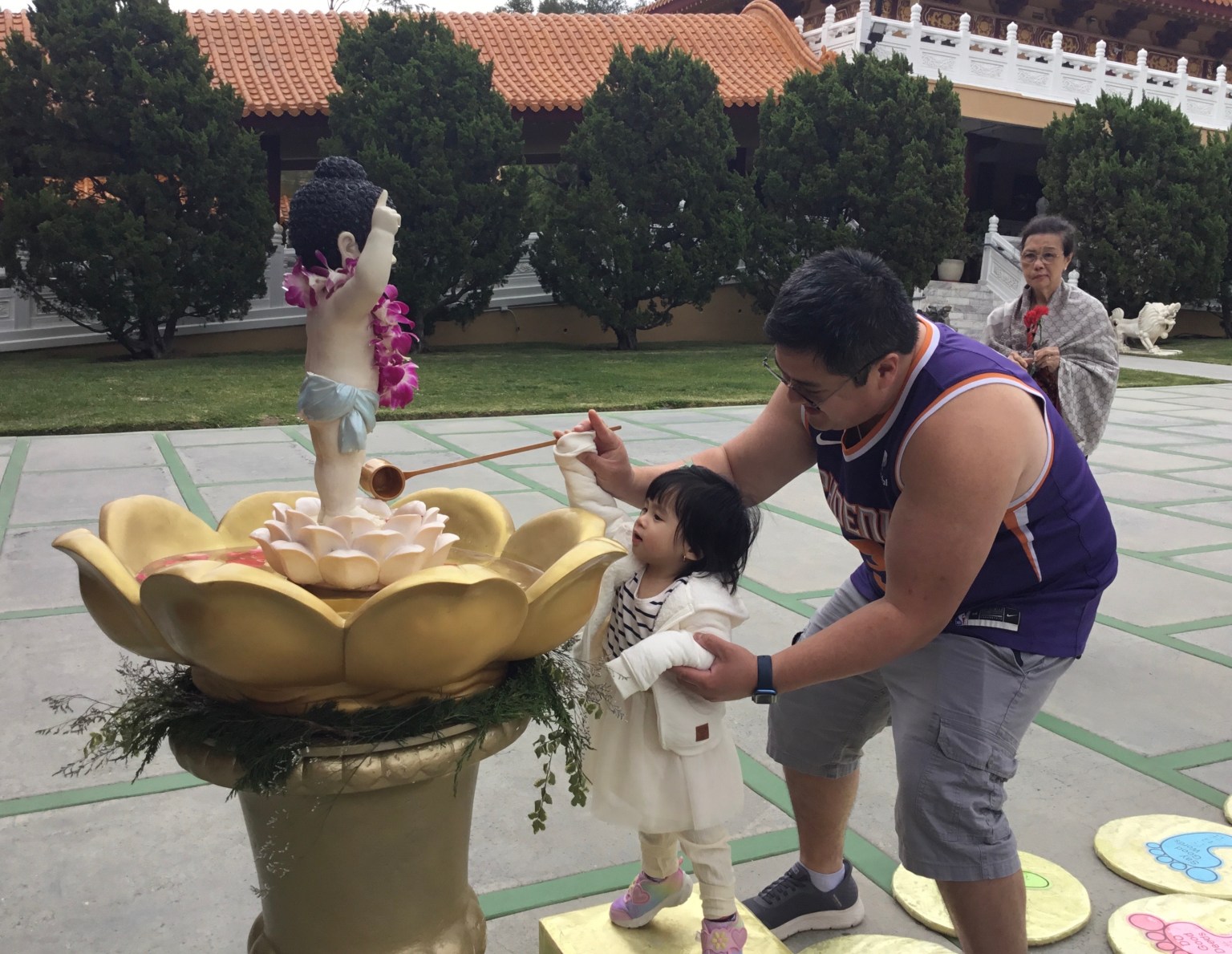 一歲半的小妹妹由父親抱起浴佛