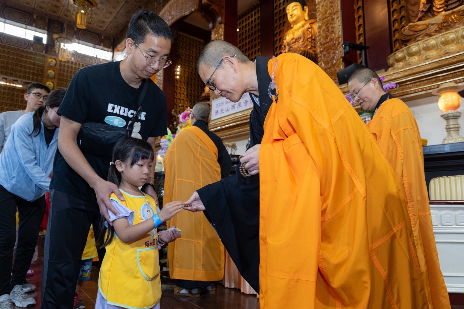 頭單監院如松法師致贈每位寶寶手珠一串。