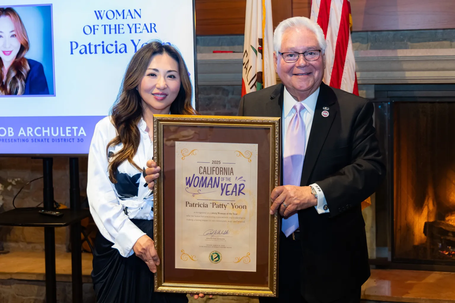 "Woman of the Year" award recipient Patricia Yoon receives her award from Senator Archuleta.