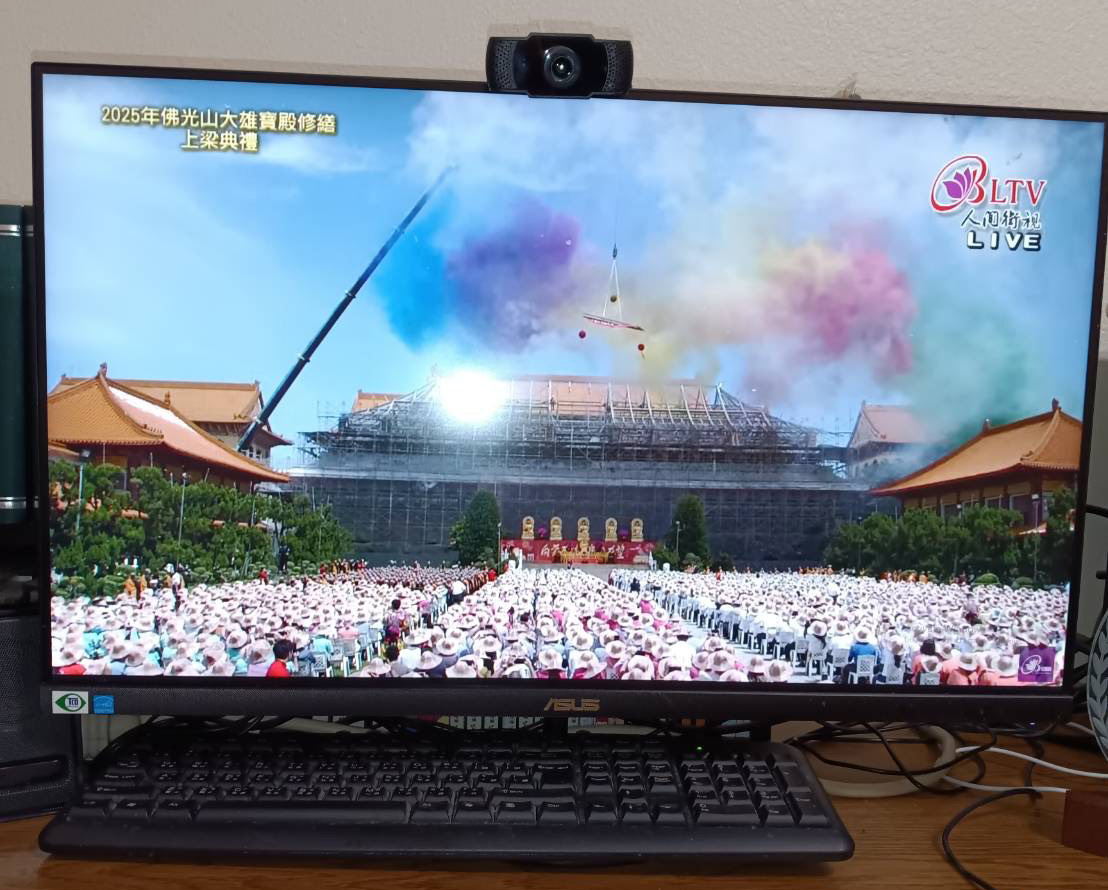 視頻觀看直播中，上樑的場景和鏡頭。現場鳴炮歡慶，五彩斑爛的彩帶及紙花升騰飛舞，照映在大雄寶殿的上空，更顯佛光普照、燈燈相傳。