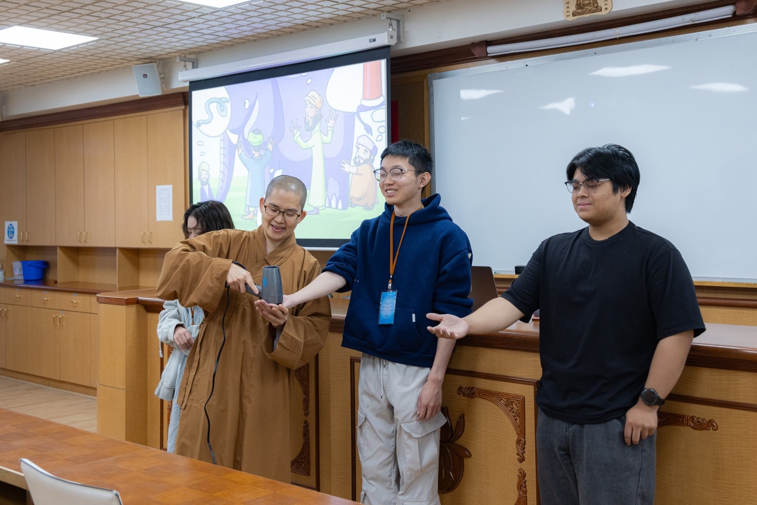 覺皇法師以《優陀那經》中「盲人摸象」的故事為例，請學員分組，閉上眼睛觸摸吹風機的一面。