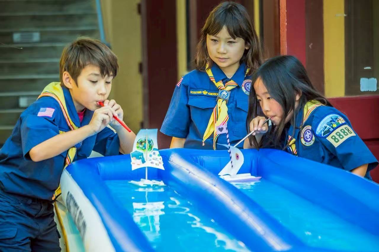 幼童軍Bryce Phelps 和 Elle Chen 努力的吹小船