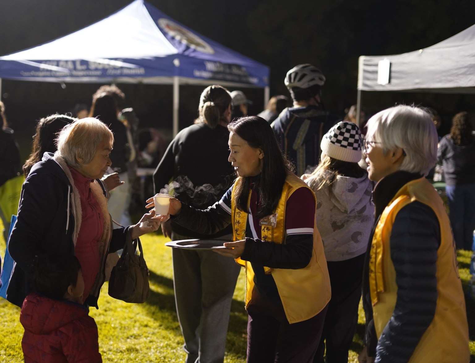 「您好！請喝西來友好熱飲！」佛光人穿梭現場，為民眾奉上熱氣騰騰的西來友好熱飲——桂香蘋果茶。