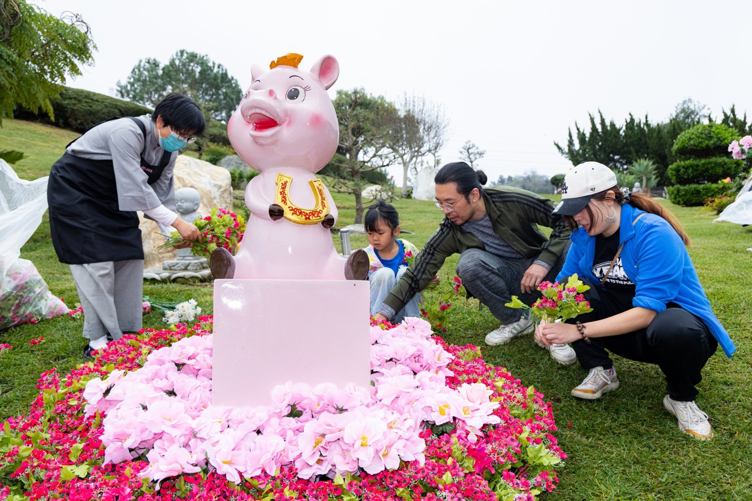 勝鬘書院學員(左)與佛光西來學校親子(右)一同布置山門口的豬寶寶。