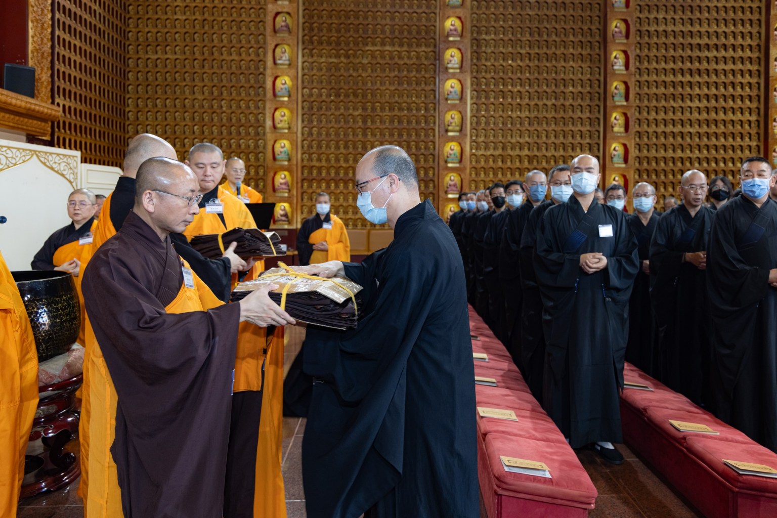 During the ordination, Venerable Hui Xuan and other guiding monastics assist with robe transmission.