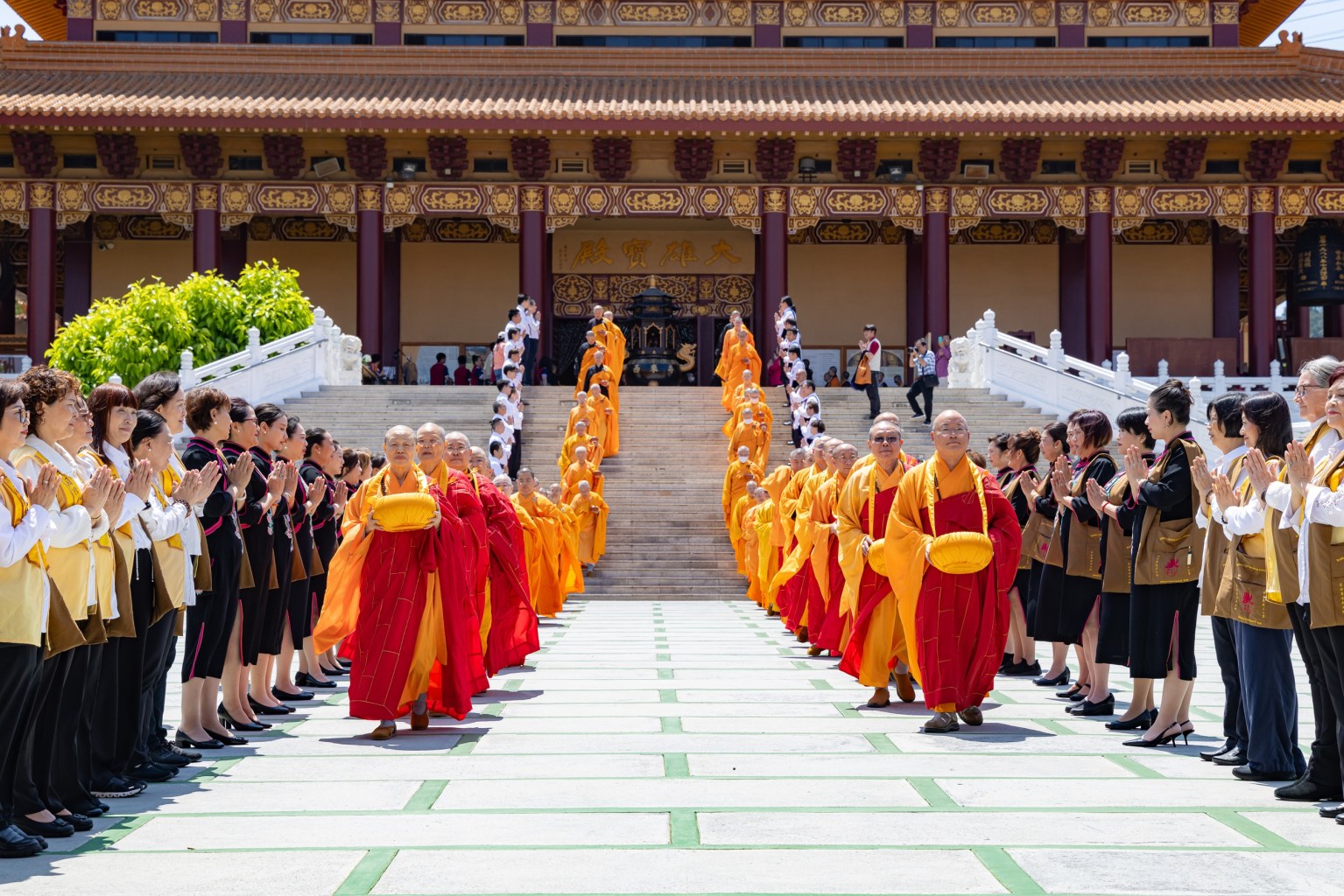 Monastics and novice monks conduct the alms-bowl offering ritual together.