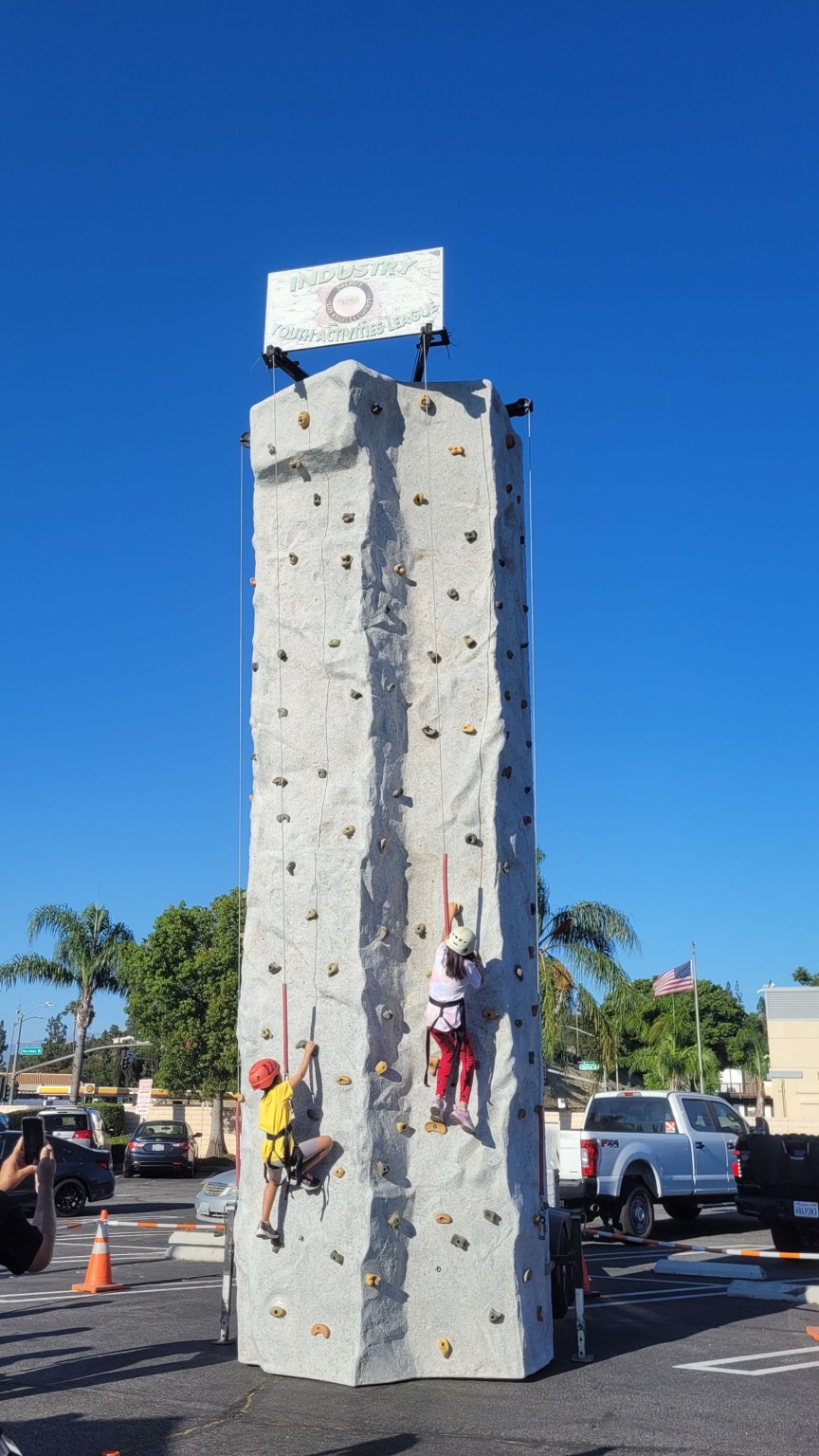 A long line forms in front of the Industry Police Department’s climbing wall, filled with laughter and excitement.