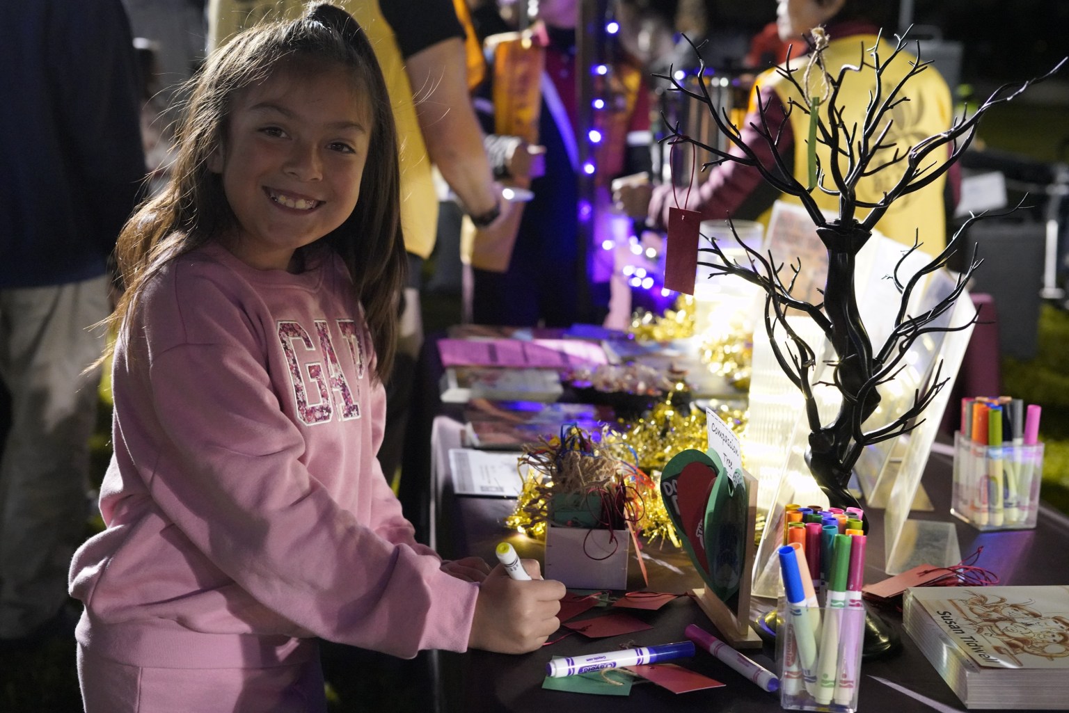 慈悲許願樹上掛著孩童寫下的期望，掛上卡片的孩童眼裡閃著光。