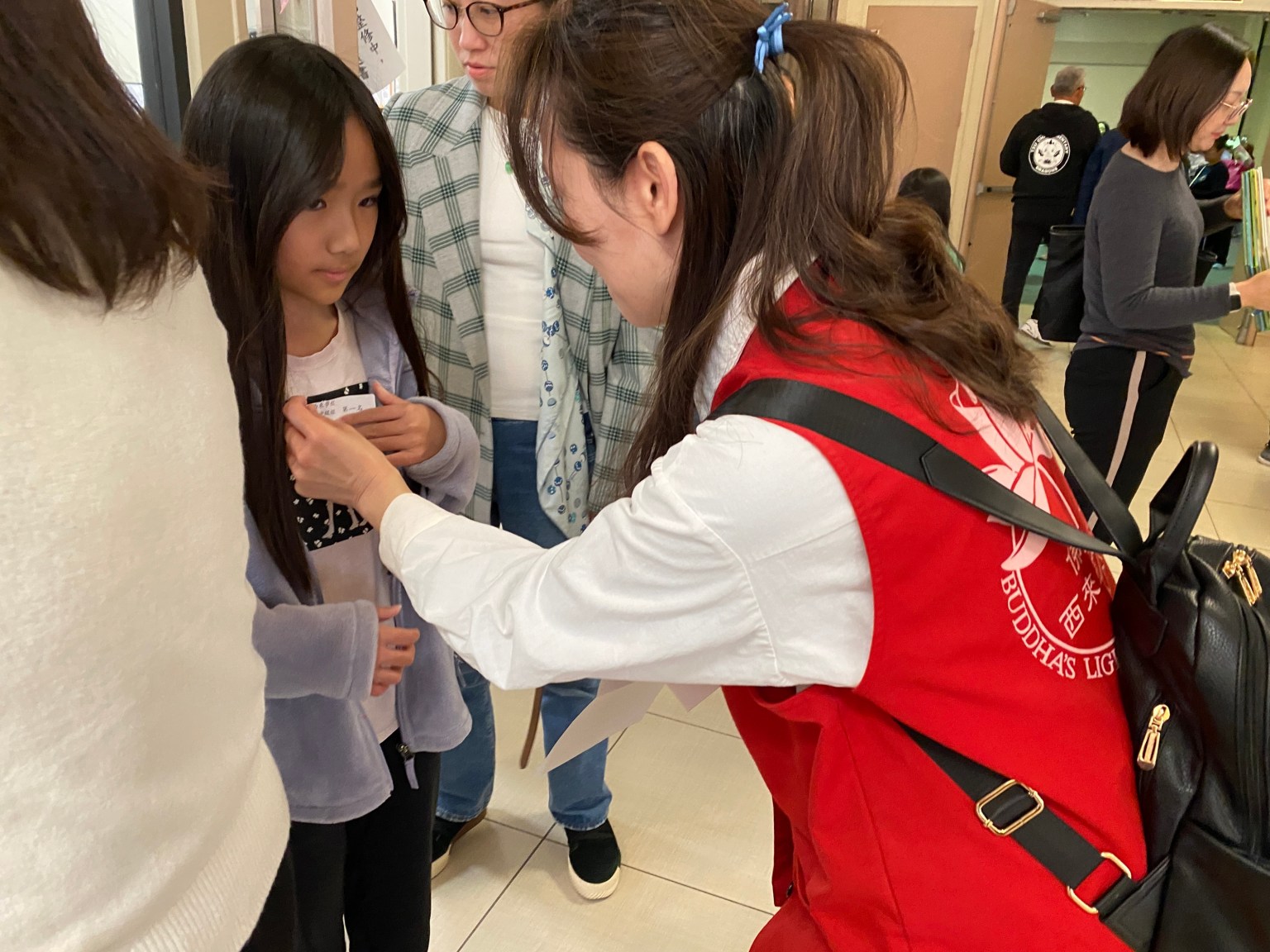 林映萱老師為學生貼上報到名牌。