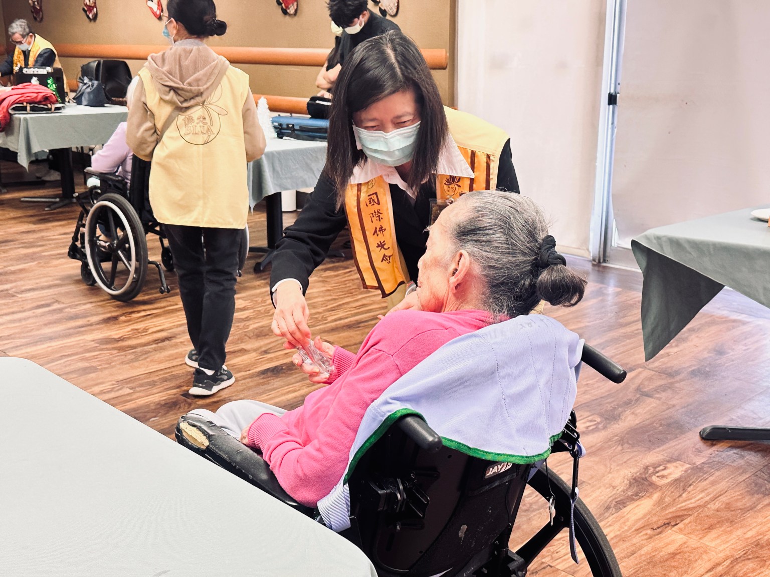 活動中,佛光人穿梭於長者之間,親切問候、握手寒暄,為每一位長者送上誠摯祝福。白塔三分會準備了由會員們親手串製、象徵吉祥與心意的祝福手珠;河濱分會則帶來低糖可口的蛋糕,象徵平安與歡喜的分享。