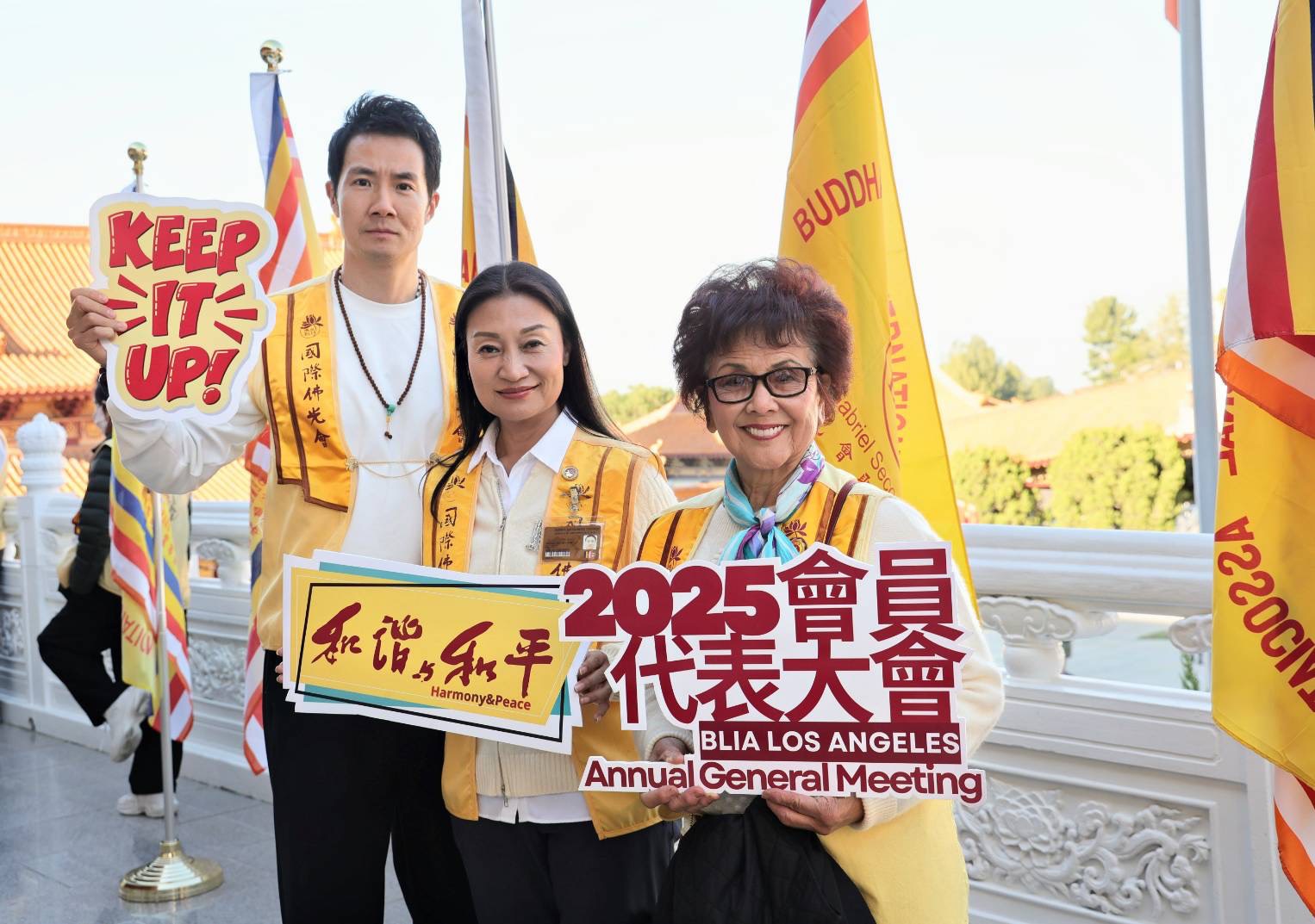 右一吳月姬督導，中間王敏會長，左一雷志鵬羅一會員舉牌2025會員代表大會和藹與和平Keep it up !