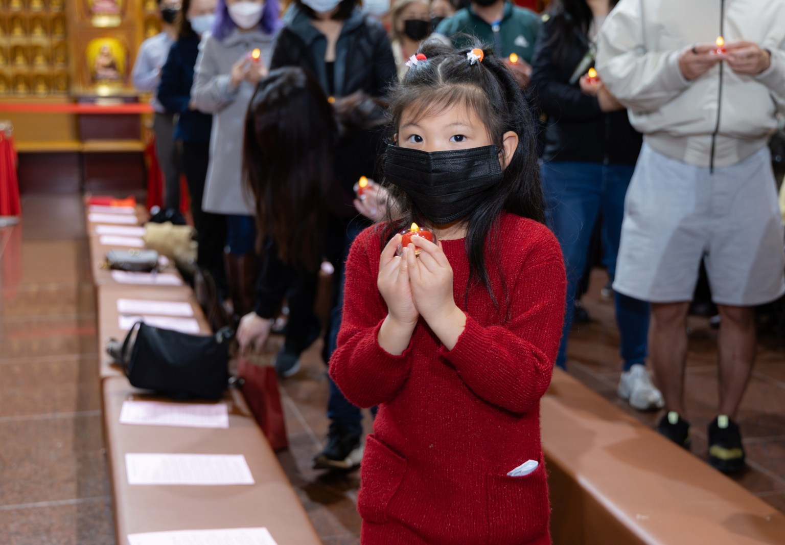 小朋友虔誠恭敬地雙手持燈。