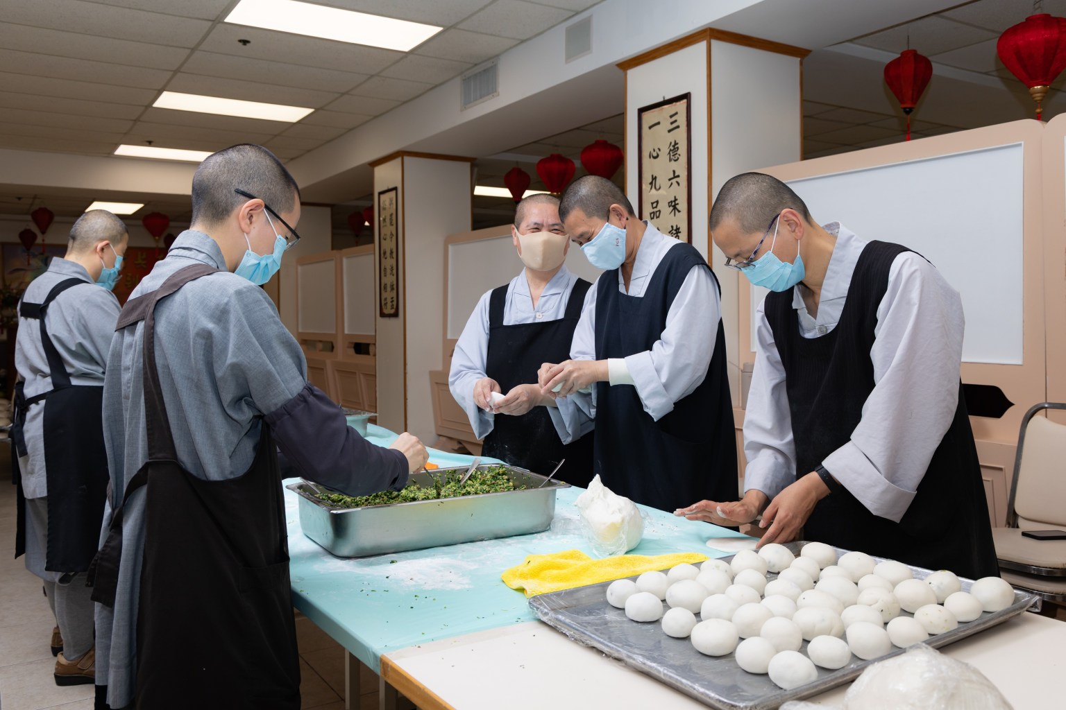 西來寺頭單監院如松法師(右2)、二單監院知行法師(左)帶領大眾藉由製作糰子寄託思念與感恩，緬懷大師教誨。
