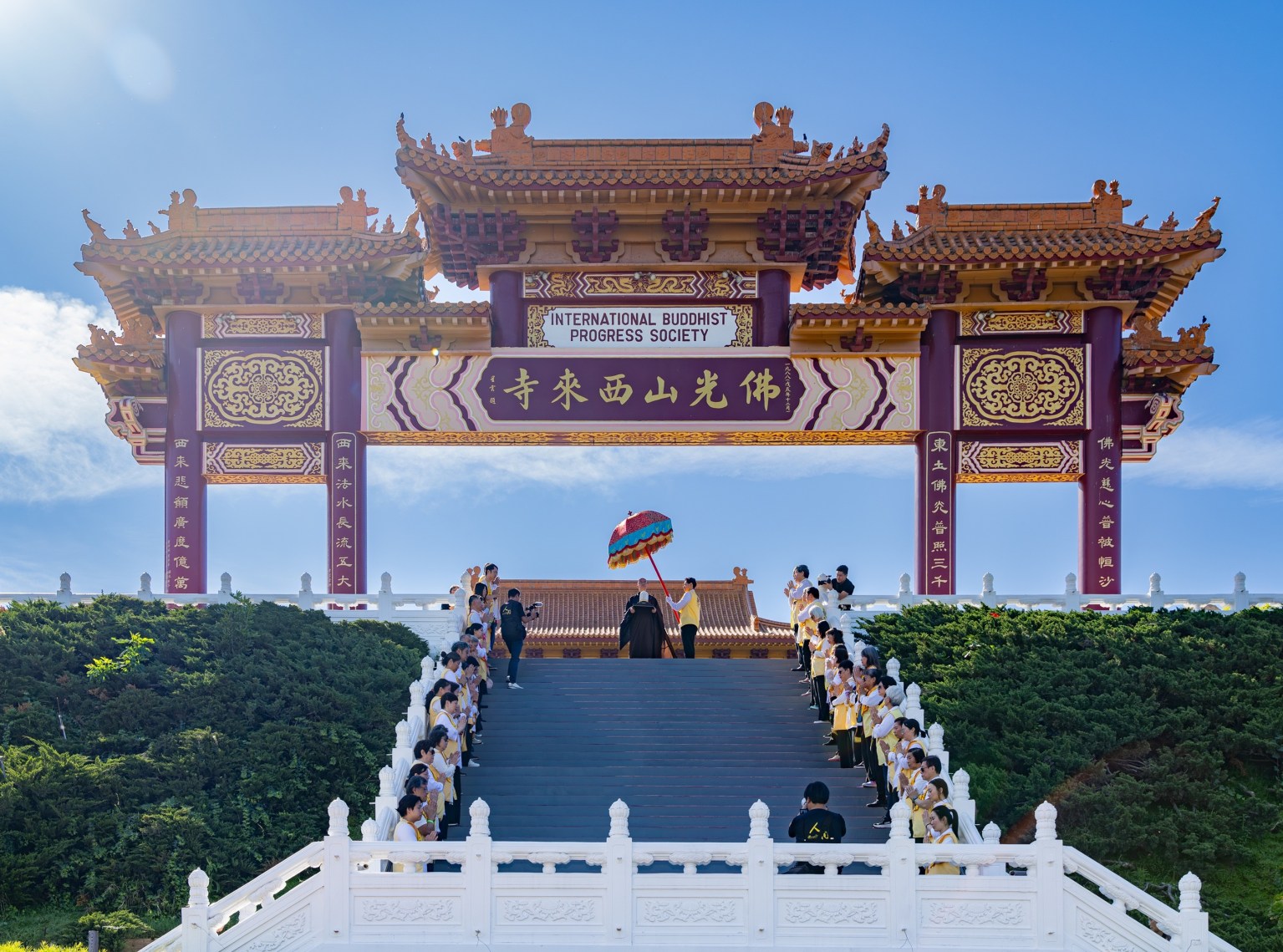 慧東法師手捧開山祖師星雲大師靈骨於頭山門回頭眺望山下。