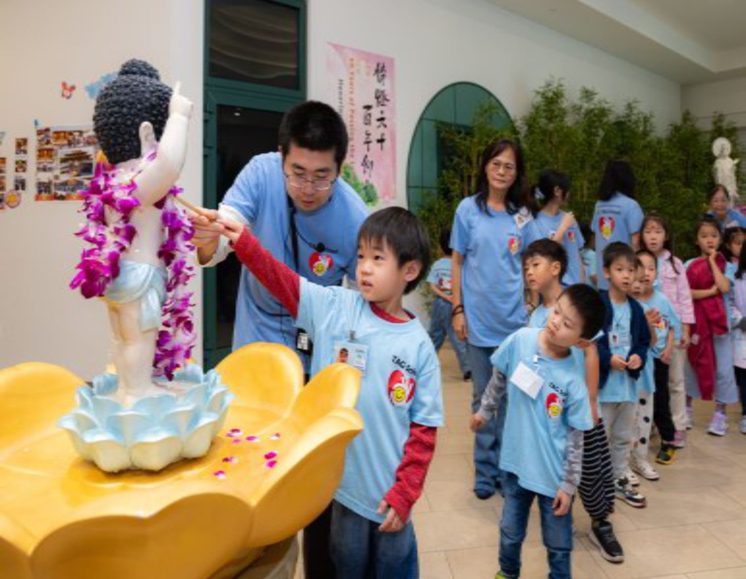 小朋友神情專注地灌沐佛身。