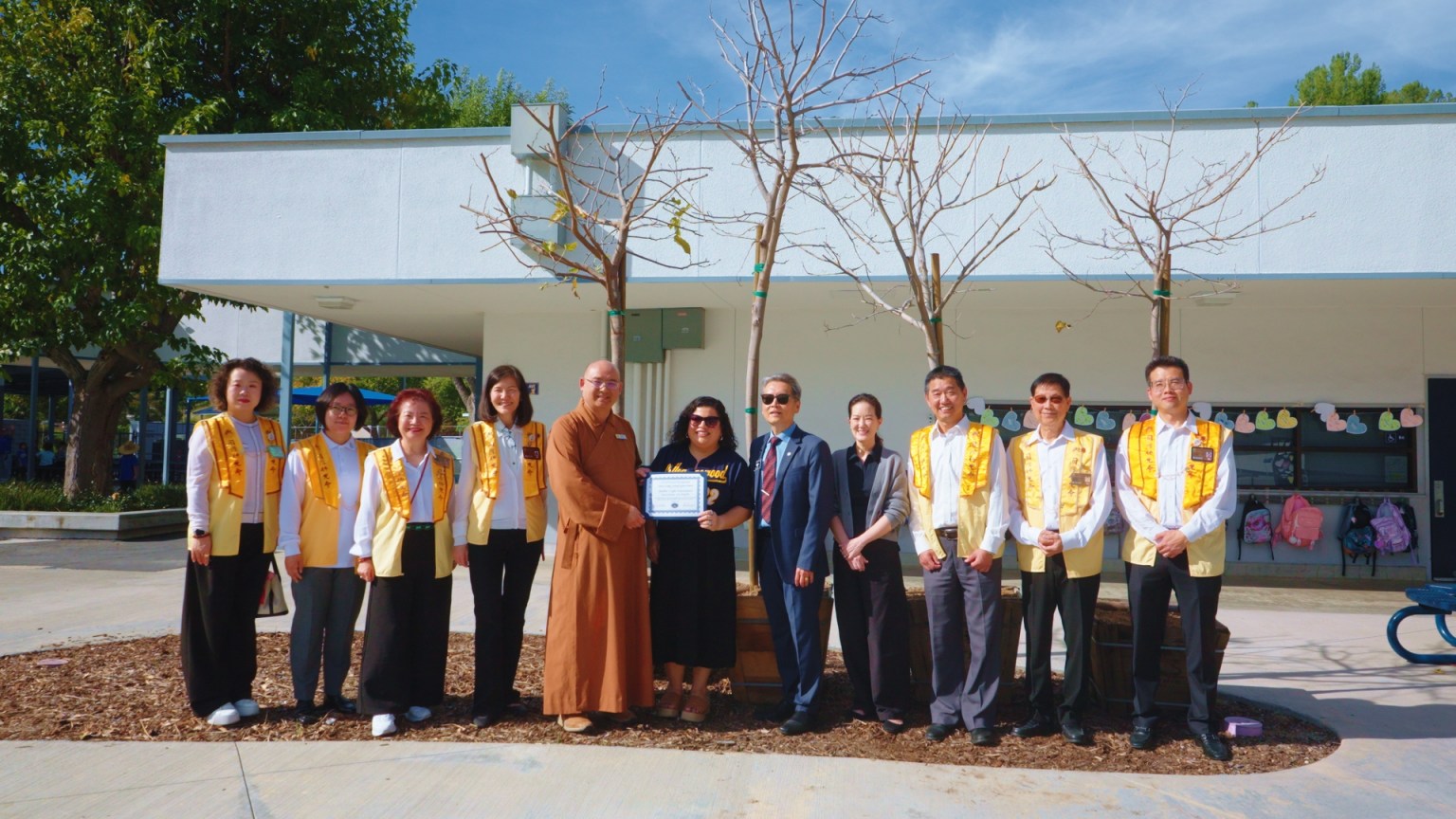 Walnut Valley Unified School District Board President Tony Torng (right, fifth) presents a Certificate of Appreciation in recognition of BLIA Los Angeles' longstanding support for education and environmental protection. Venerable Huize (left, fifth) accepts the certificate on behalf of the organization.