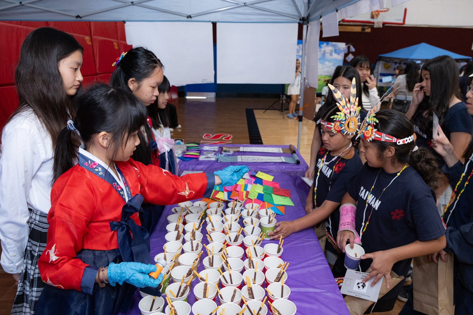 The Hsi Lai Girl Scouts prepare chocolate sticks, Korean kimchi bibimbap, banana milk, and handmade souvenirs for visitors.