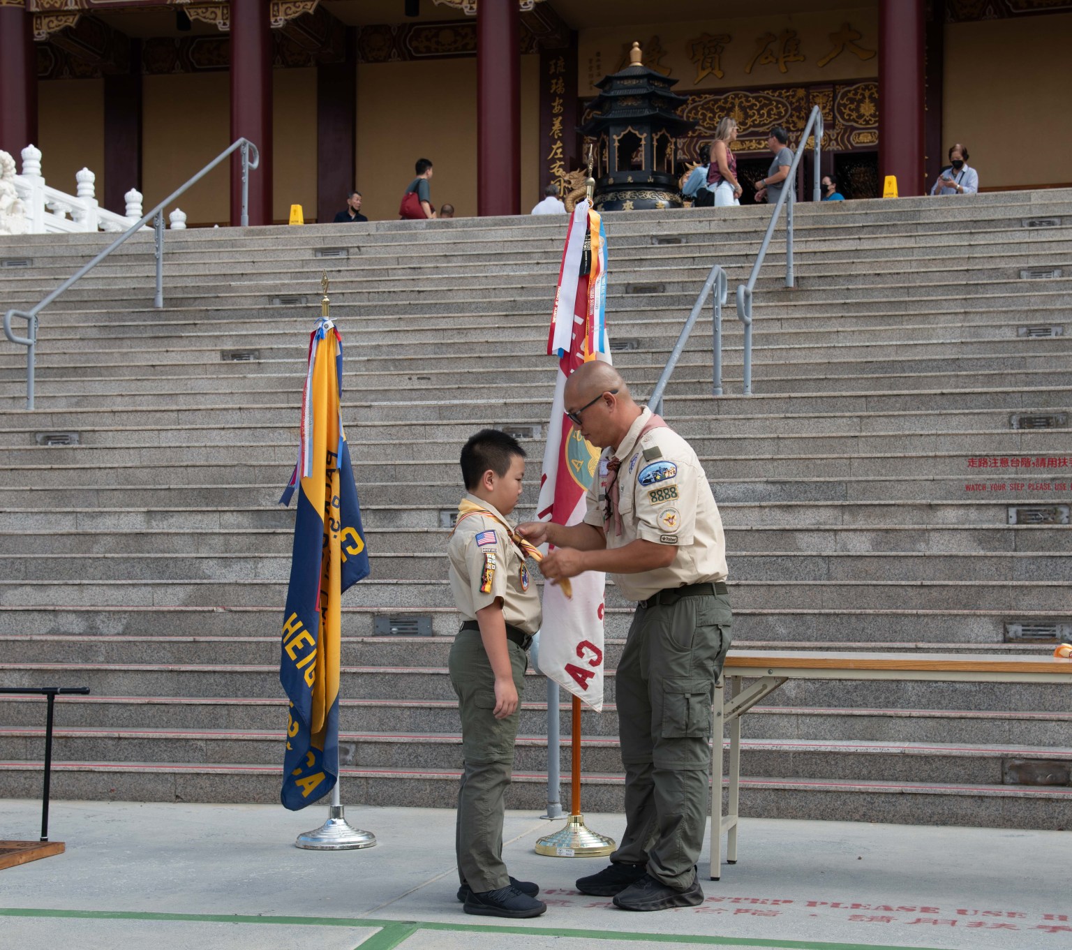 幼童軍Carson Che(左)逐一跨越由17片木板組成的橋,象徵童軍成長過程中的不同階段。